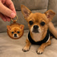 Hand holding a custom round leather keychain featuring a tan Chihuahua portrait beside the real dog.