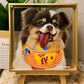 Custom glass portrait of a smiling brown-and-white long-haired dog in a yellow outfit, displayed in a gold-tone frame on a wooden easel.