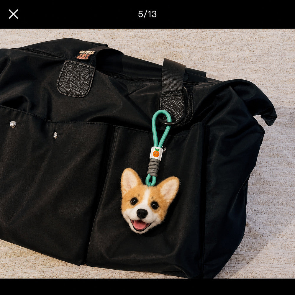Personalized Corgi head charm with a green hanging loop attached to a black travel bag.