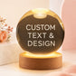 Personalized crystal ball night light with custom text and design displayed on a warm LED wooden base.