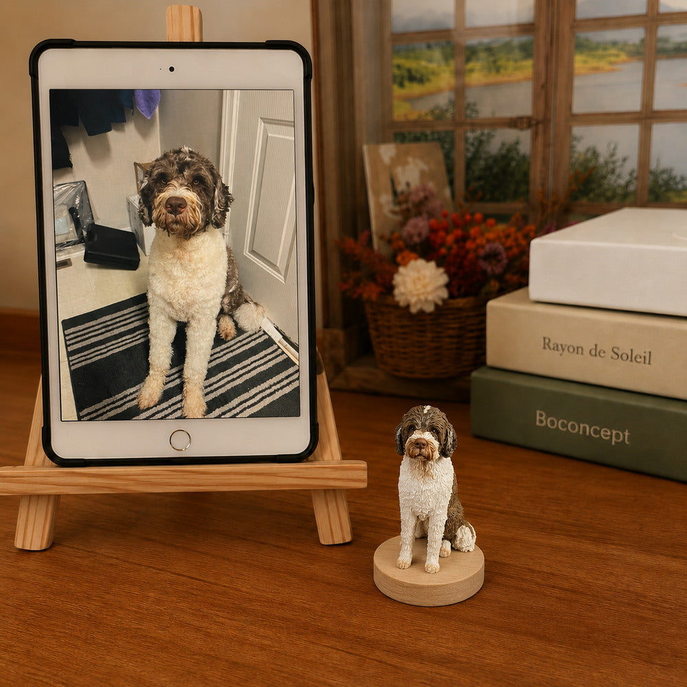 Custom brown and white curly-haired dog figurine displayed beside the pet’s reference photo on a tablet.
