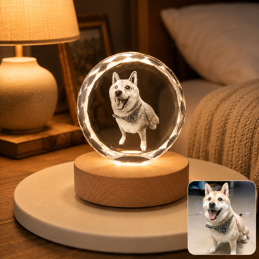 Personalized dog portrait engraved inside a faceted round crystal night light with a warm wooden LED base, shown beside the original pet photo.
