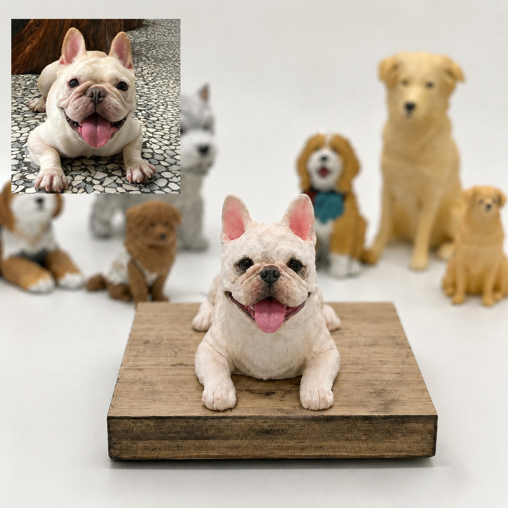 Custom cream French Bulldog figurine in a lying pose displayed on a wooden base beside the pet’s reference photo.