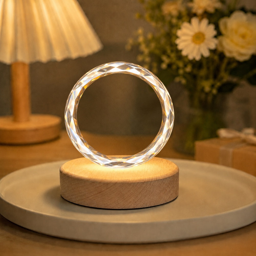 Round faceted crystal pet portrait night light glowing on a wooden LED base in a warm home setting.
