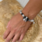 Personalized black-and-white dog portrait bracelet worn with black, gray and white crystal beads.
