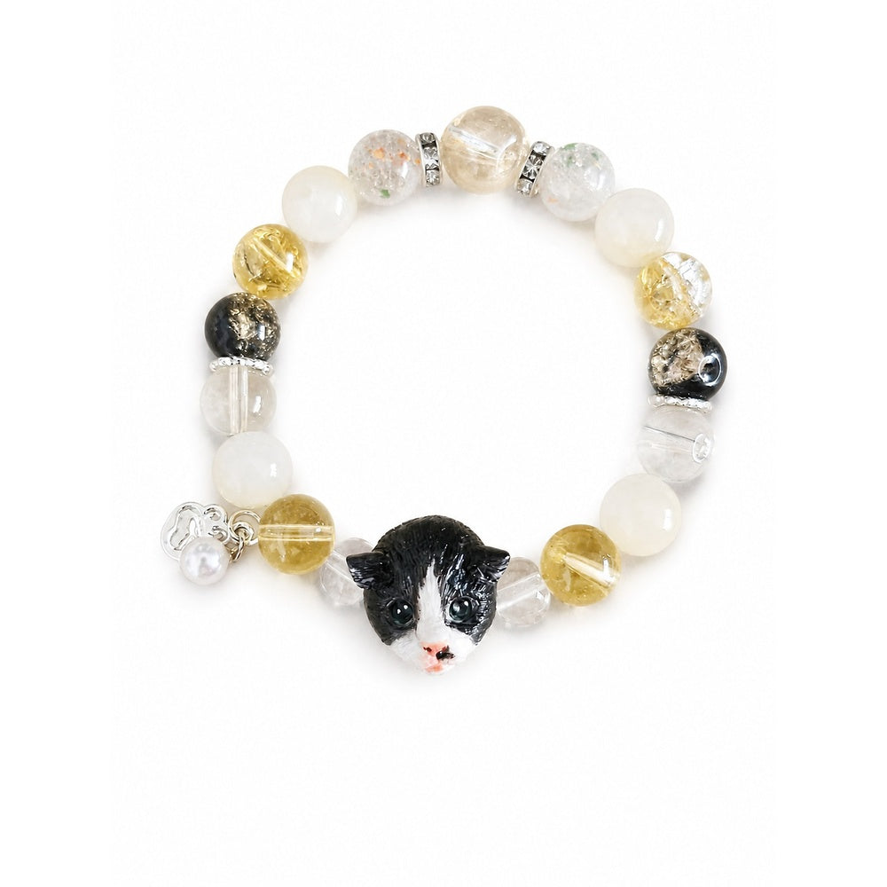 Custom black-and-white folded-ear cat portrait bracelet with black, white and gold beads on white.