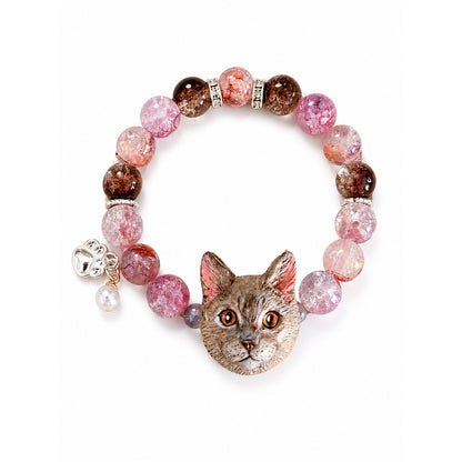 Handmade gray-brown cat portrait bracelet with orange eyes and pink crystal beads on white.