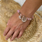 Personalized gray-brown cat portrait bracelet with orange eyes, worn with pink crystal beads.