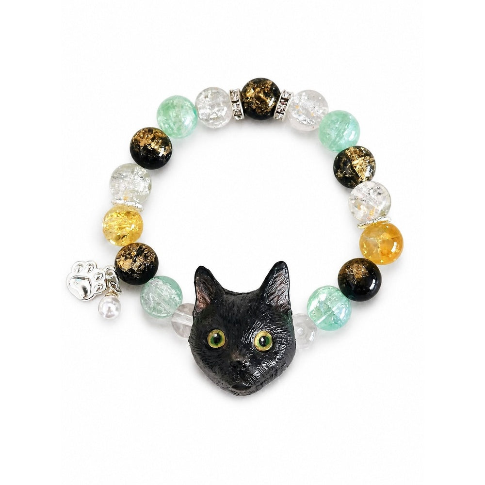 Handmade black cat portrait beaded bracelet with yellow, black and green crystal beads on white.