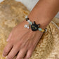 Personalized black cat portrait bracelet worn on the wrist with yellow, black and green crystal beads.