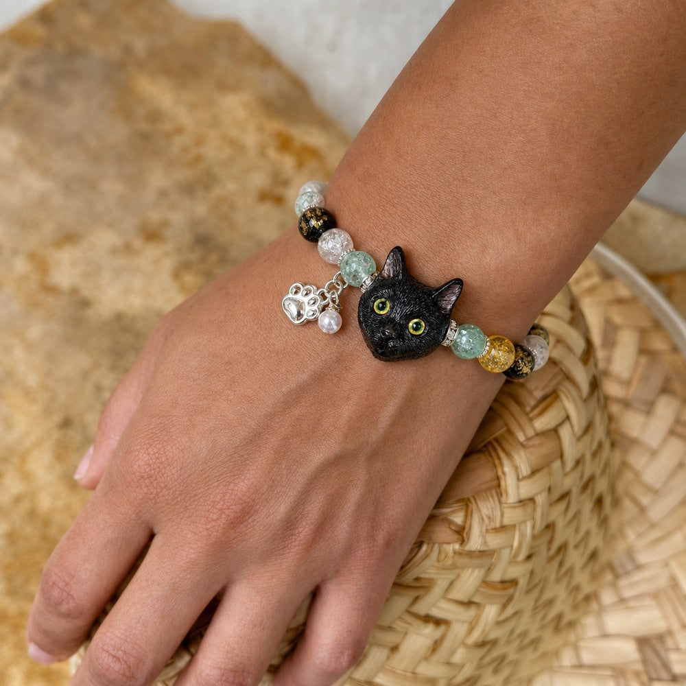 Personalized black cat portrait bracelet worn on the wrist with yellow, black and green crystal beads.