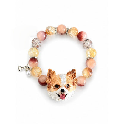 Handmade orange-and-white fluffy dog portrait bracelet with peach and clear crystal beads on white.