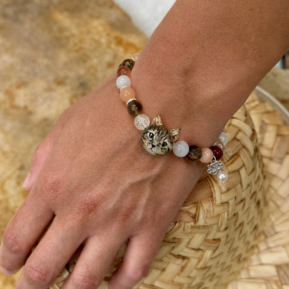 Personalized tabby cat portrait bracelet worn on the wrist with brown, white and peach crystal beads.