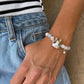 Personalized brown-and-white rabbit portrait bracelet worn with pale pink and clear crystal beads.