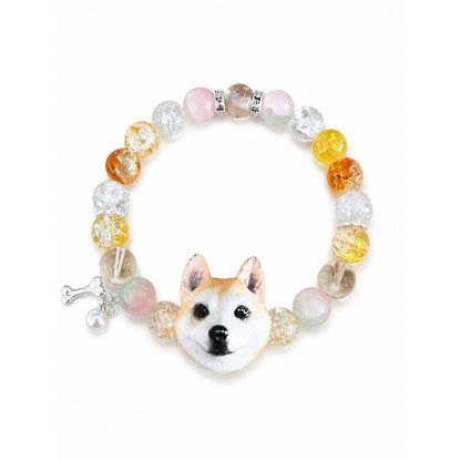 Custom tan-and-white upright-ear dog portrait bracelet with yellow, pink and clear beads on white.