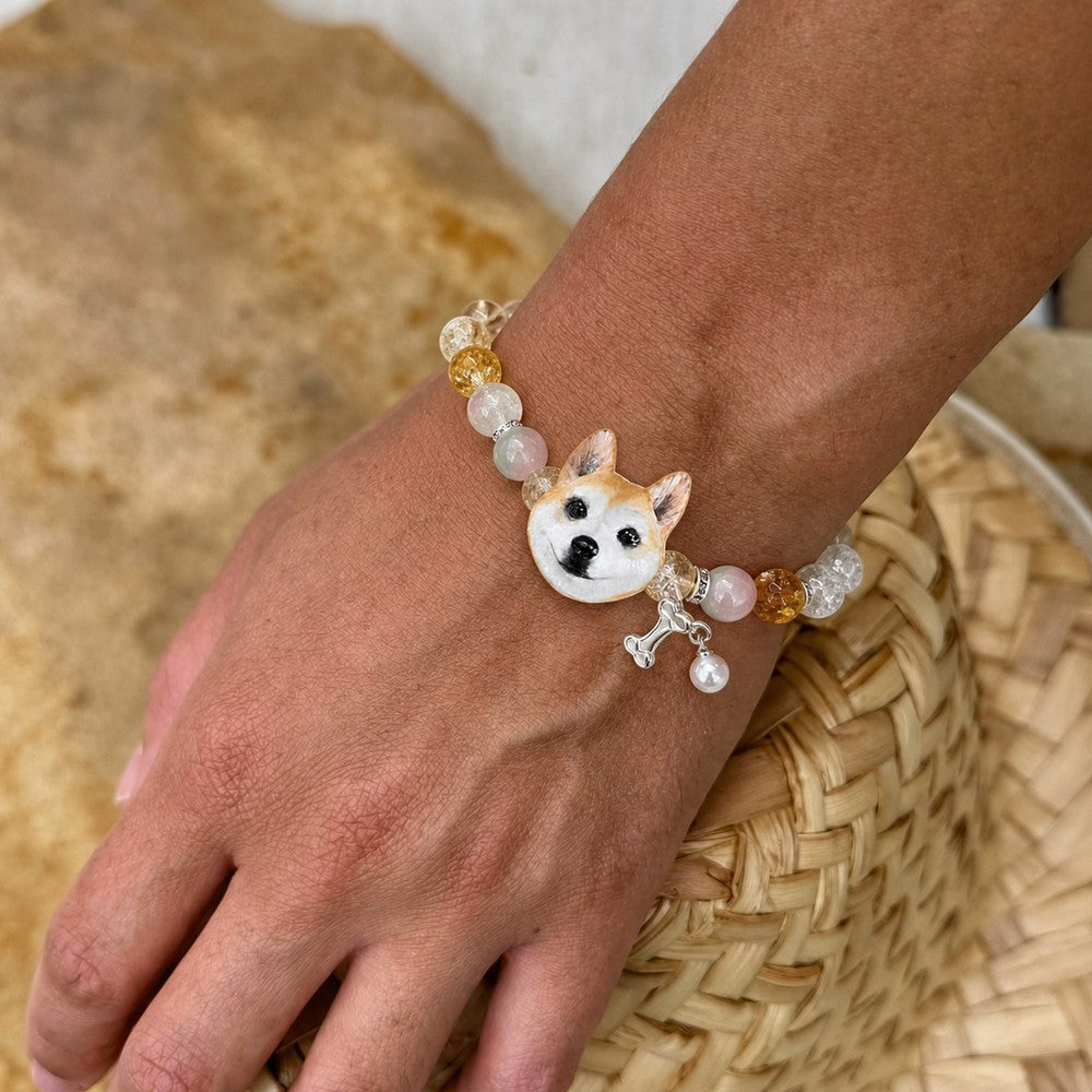 Personalized tan-and-white upright-ear dog portrait bracelet worn with pastel crystal beads.