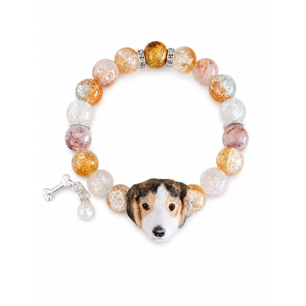 Custom tricolor floppy-ear dog portrait bracelet with peach, amber and clear beads on white.