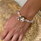 Personalized tricolor floppy-ear dog portrait bracelet worn with peach and clear crystal beads.
