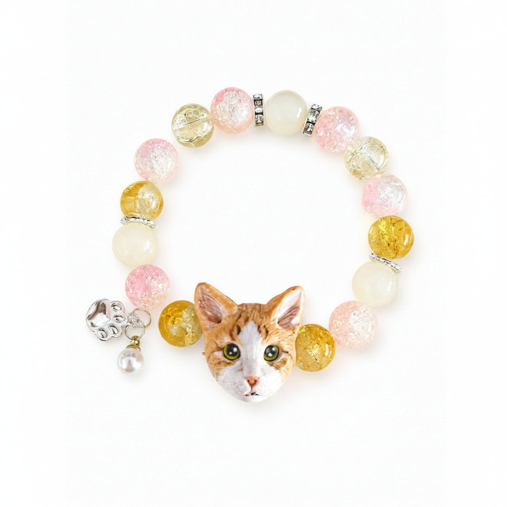 Custom orange-and-white cat portrait bracelet with yellow, pink and white crystal beads on a white background.