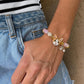 Personalized orange-and-white cat portrait beaded bracelet worn on the wrist with pastel crystal beads.