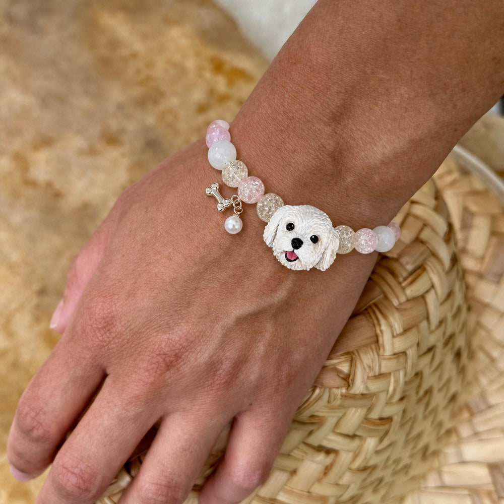Personalized white fluffy dog portrait bracelet worn on the wrist with pale pink crystal beads.