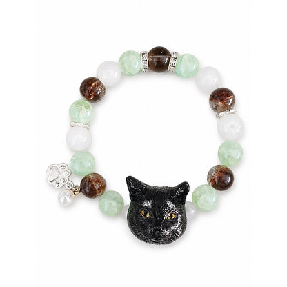 Handmade black cat portrait beaded bracelet with green, brown and white crystal beads on a white background.