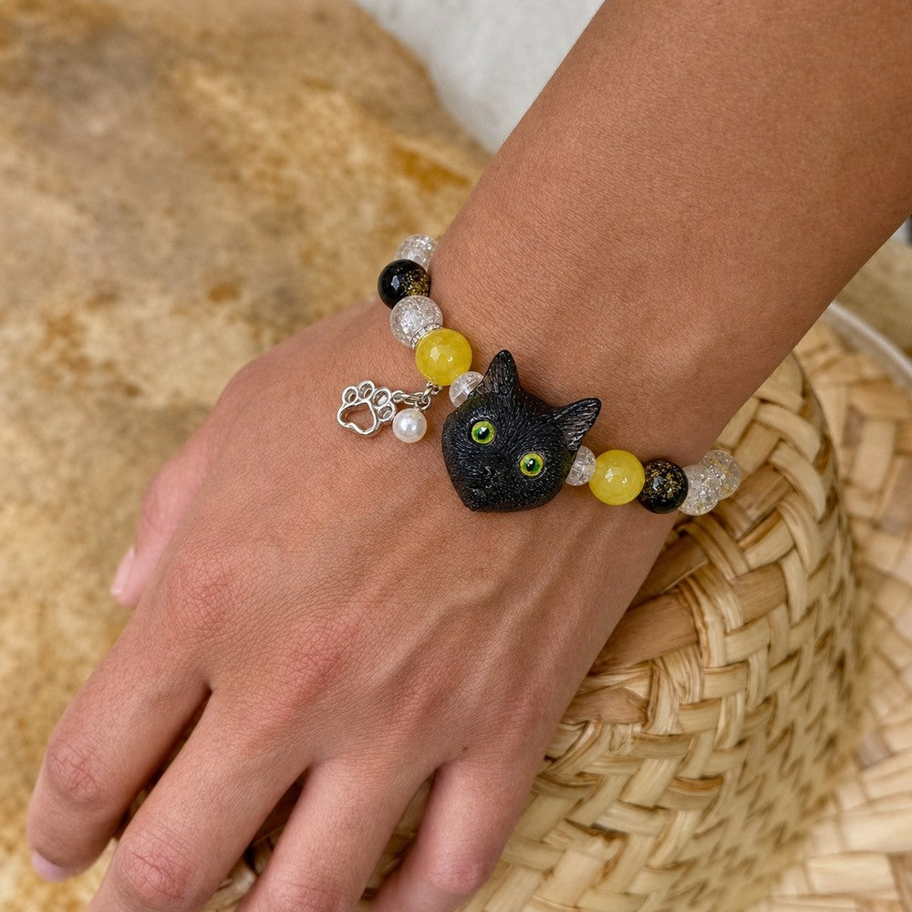 Personalized black cat portrait bracelet worn on the wrist with yellow and black crystal beads.