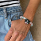 Personalized black-and-white folded-ear cat portrait bracelet worn with pastel pink and aqua crystal beads.