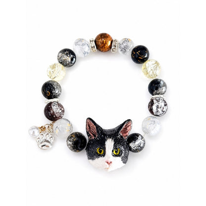 Handmade black-and-white cat portrait beaded bracelet with black and clear crystal beads on white.