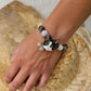 Custom black-and-white cat portrait bracelet worn on the wrist with black and clear crystal beads.