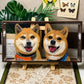 Custom glass pet portrait of two Shiba Inu dogs wearing orange and blue harnesses, displayed on a wooden easel.