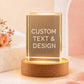 Personalized square crystal night light with custom text and design displayed on a warm wooden LED base.