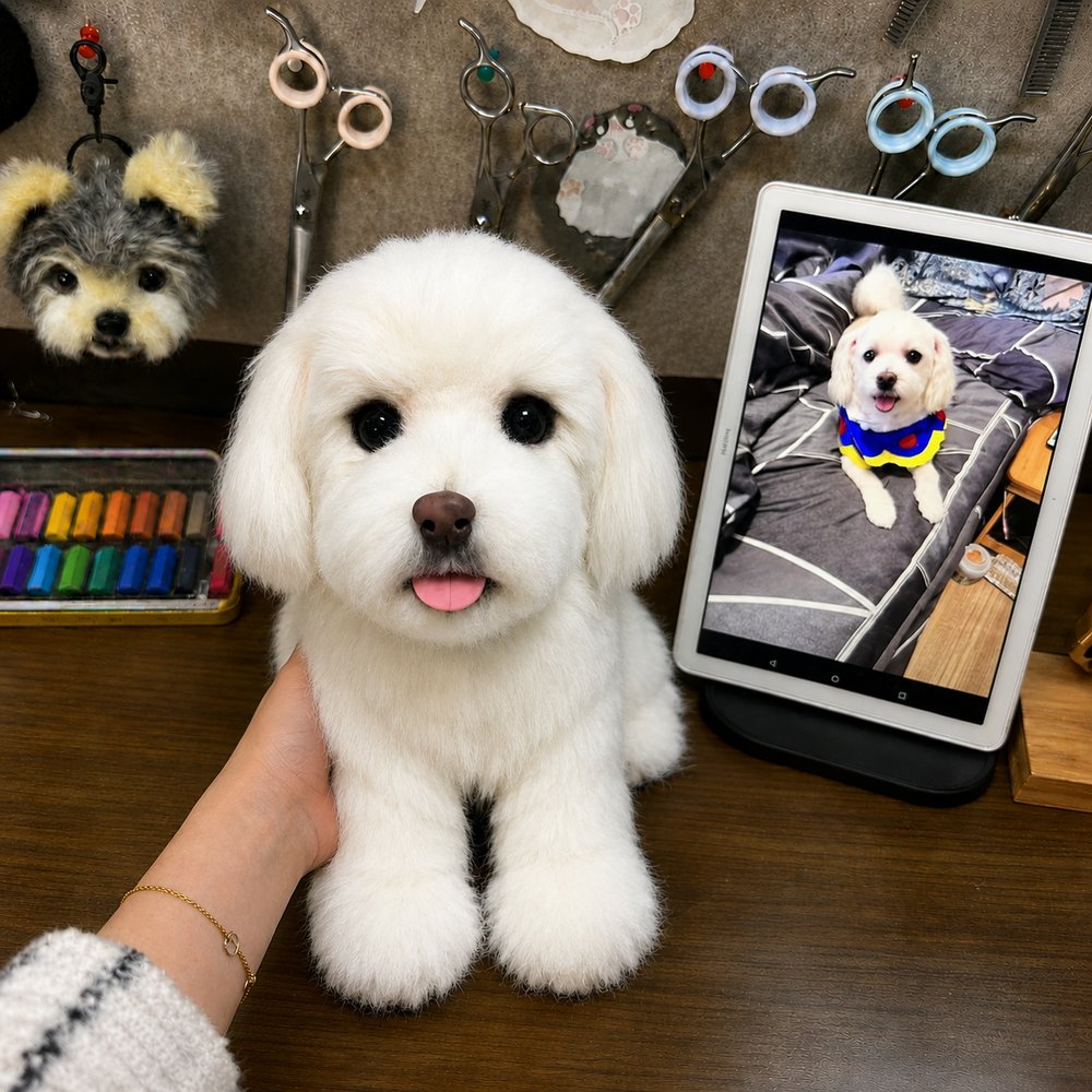 Handmade replica of a small white dog displayed beside the customer’s reference photo on a tablet in an artisan workshop.