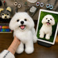 Lifelike handmade replica of a small white dog displayed beside its reference photo on a tablet in an artisan workshop.