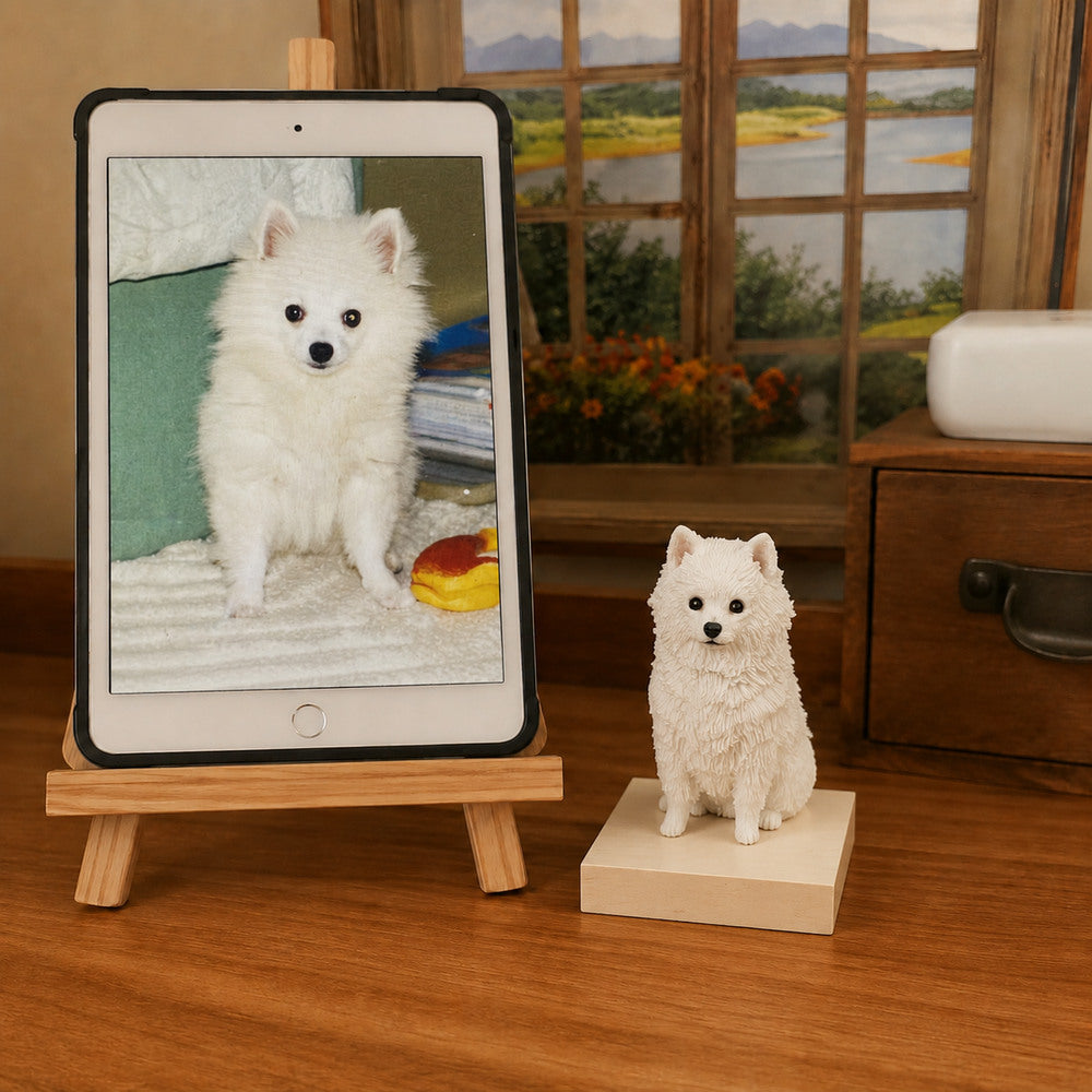 Custom white Spitz dog figurine displayed beside the pet’s reference photo on a tablet.