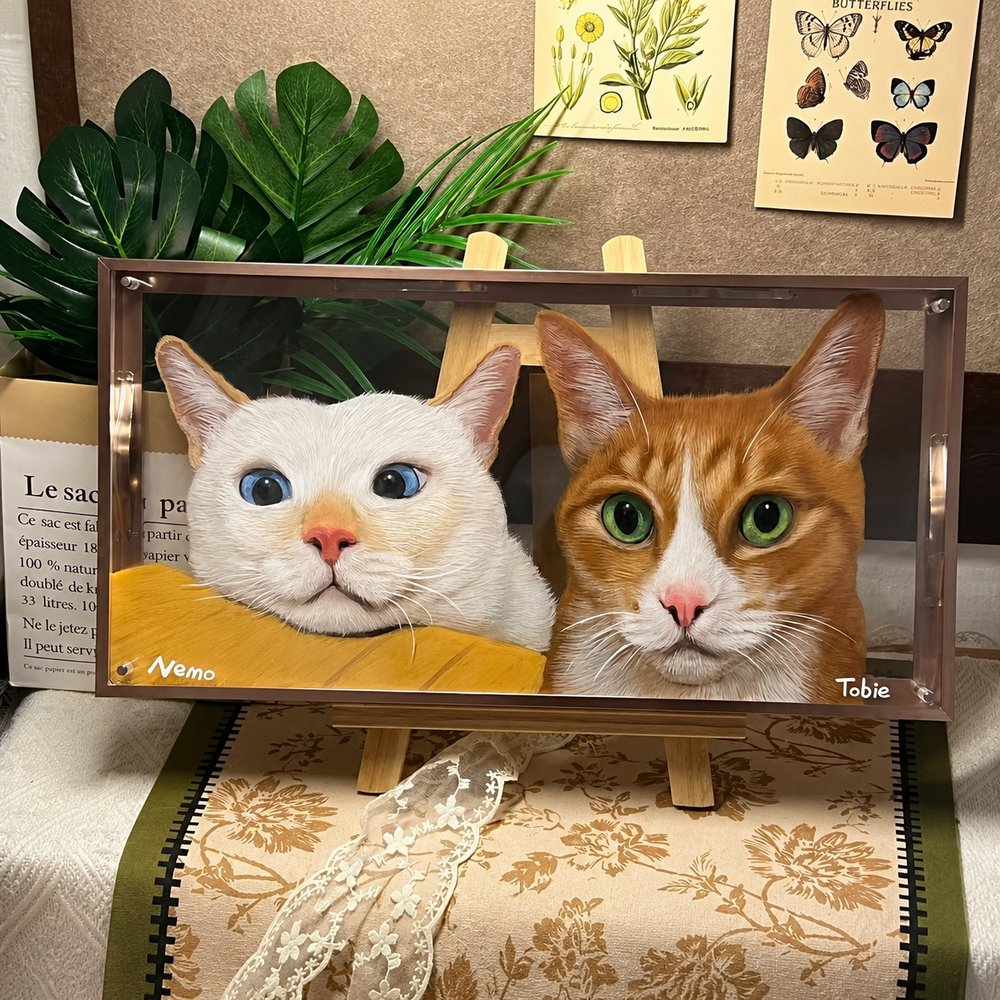 Custom glass pet portrait of a white cat and orange tabby named Nemo and Tobie, displayed on a wooden easel.