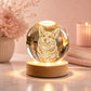 Custom 3D dog portrait crystal ball night light glowing on a round wooden base in a warm pink home setting.