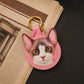 Custom pink leather keychain featuring a detailed tortoiseshell-and-white cat portrait with green eyes and gold-tone hardware.