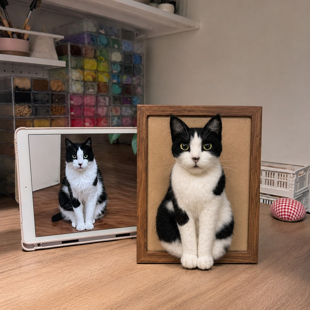 Handmade full-body 3D felt portrait of a black and white tuxedo cat displayed in a wooden frame beside the cat’s reference photo.