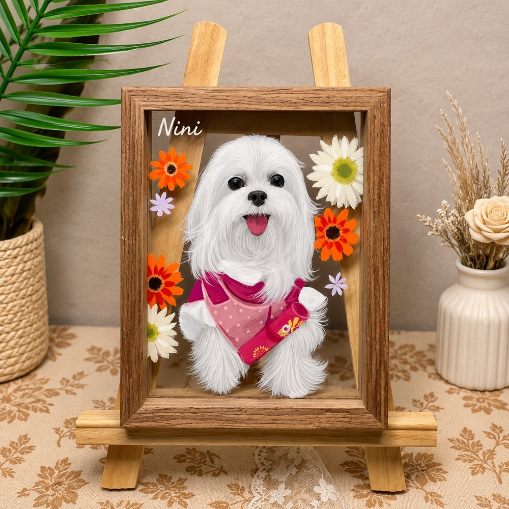 Custom glass pet portrait of a white Maltese named Nini wearing a pink bandana, surrounded by colorful flowers in a wooden frame.